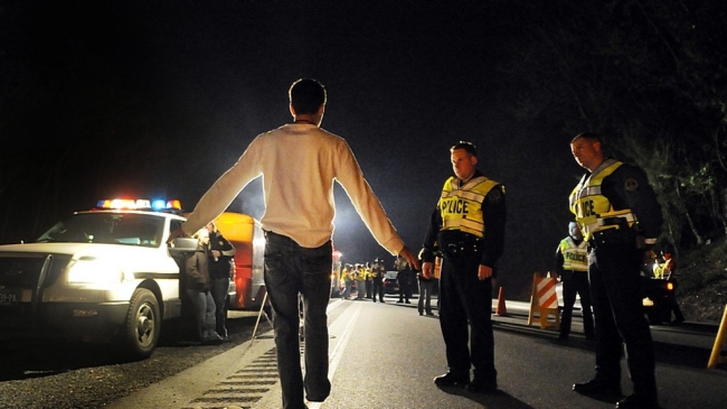 West Manchester Township Police Officer Adam Bruckhart, left, and York Area Regional Police Officer Mike Georgiou observe a driver suspected of being under the influence of alcohol as he performs a field sobriety test at a DUI checkpoint on the business loop of Interstate 83 Friday, April 23, 2010. The driver was later arrested on suspicion of DUI. DAILY RECORD/SUNDAY NEWS - KATE PENN
